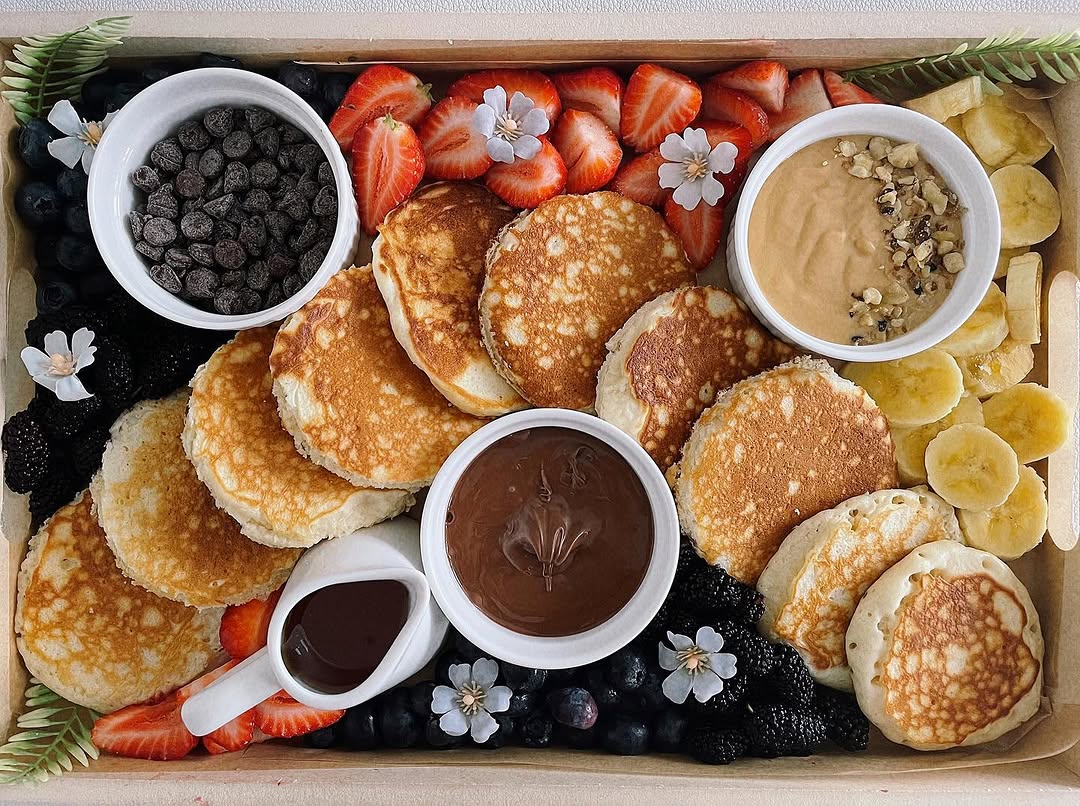Caja de pancakes con frutas y chocolate
